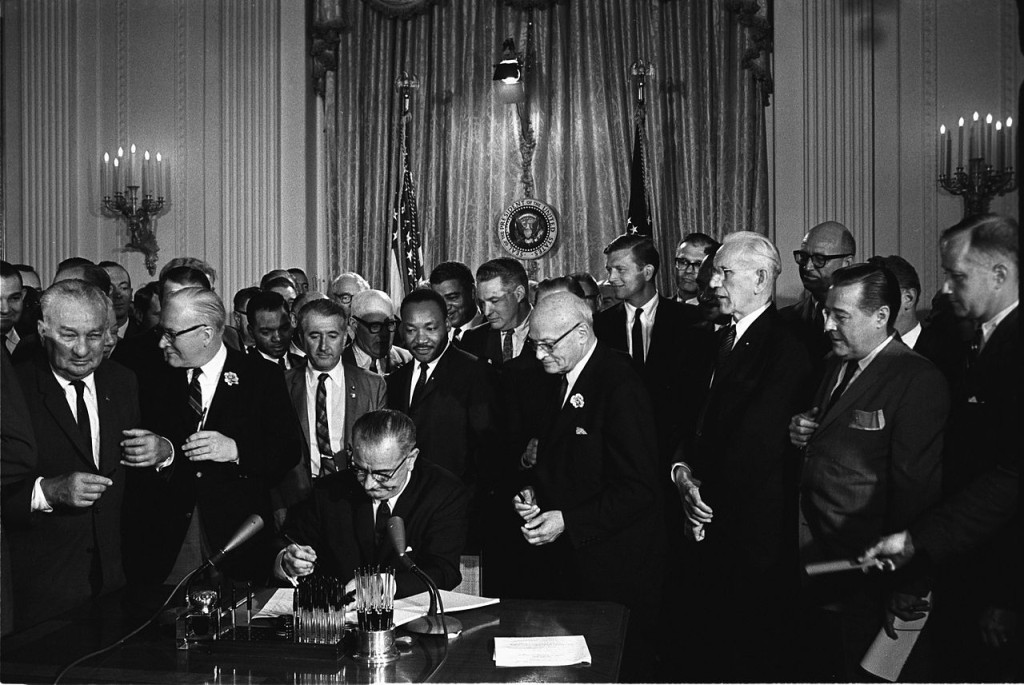 President Johnson signs the 1964 Civil Rights Act; notice King standing behind him.